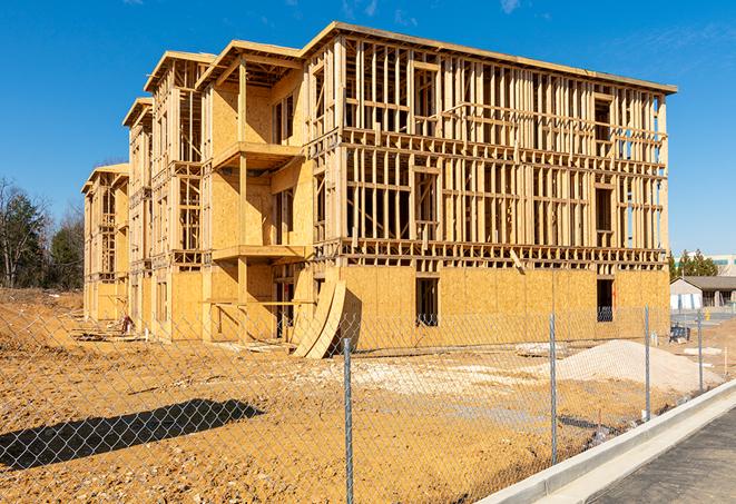 workers protected by temporary barrier fence during building maintenance in Colton